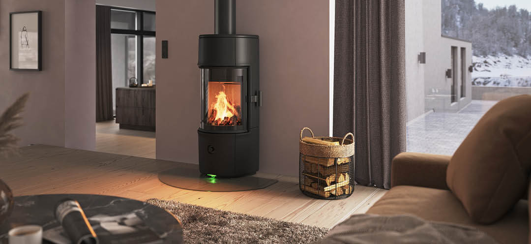 Moderne rom med liten svart Jøtul F 171 vedovn, pudderlilla vegger og snødekt fjellutsikt