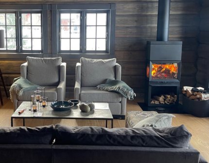 Jøtul F 520 HT sort vedovn i en grå hytte